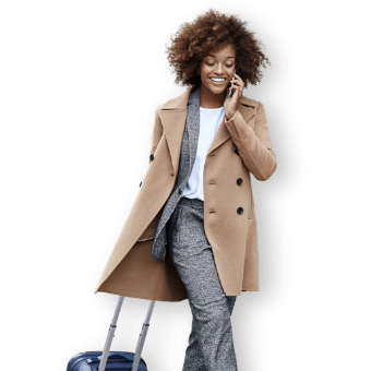 Donna sorridente che cammina con un trolley 